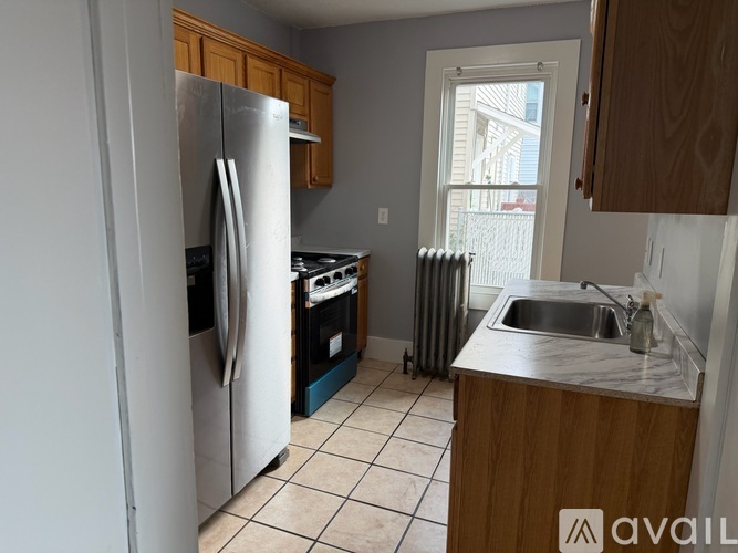 A kitchen with a refrigerator, sink, and stove.