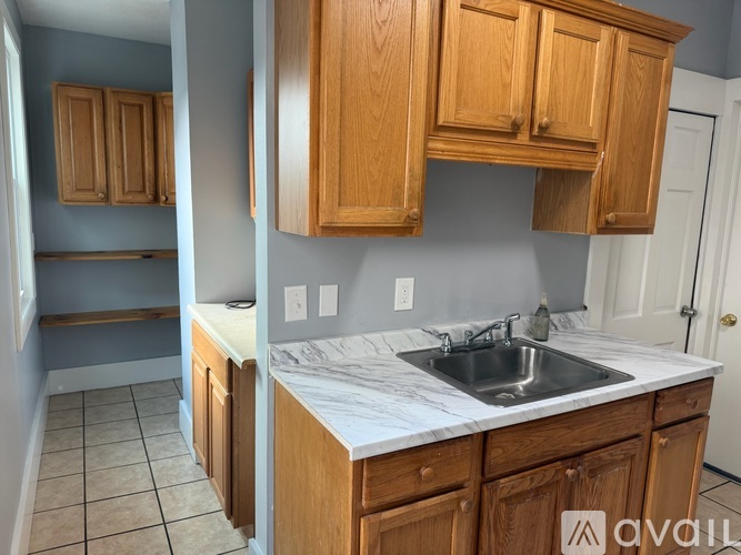 A kitchen with wooden cabinets and a marble countertop.