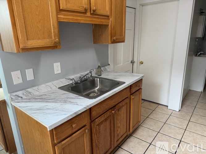 A kitchen with wooden cabinets and a marble countertop.