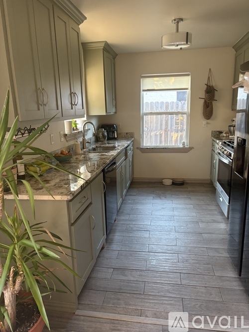 A kitchen with a tile floor and a window.