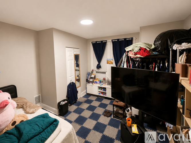 A room with a bed, a TV, and a checkered floor.