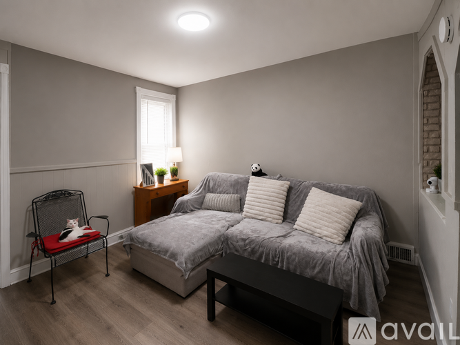 A bedroom with a bed, chair, and nightstand.