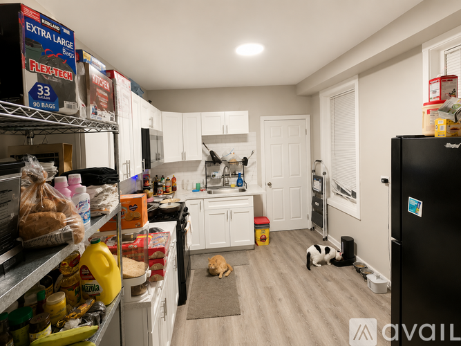 A kitchen with a black fridge and a black stove top.
