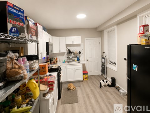 A kitchen with a black fridge and a black stove top.