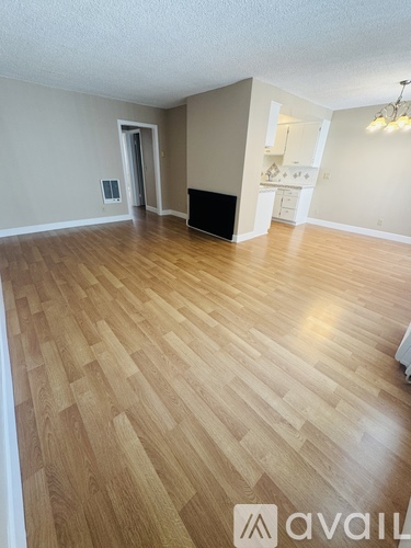 A room with wooden flooring and a black couch.