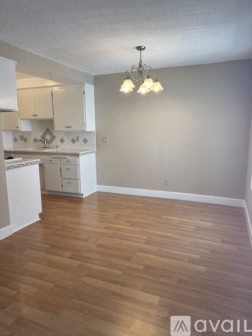 A kitchen with wooden floors and a chandelier.
