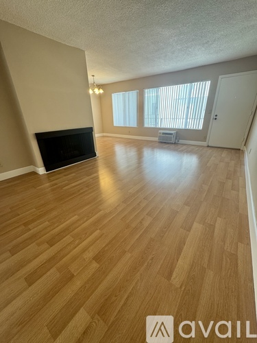 A room with wooden flooring and a fireplace.