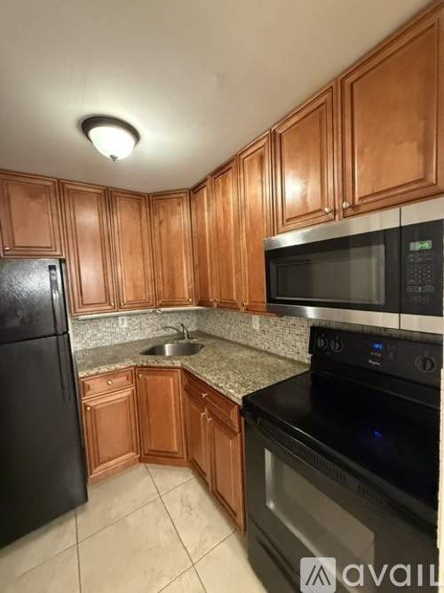 A kitchen with wooden cabinets and black appliances.