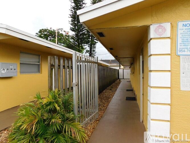 A long yellow building with a sign on it.