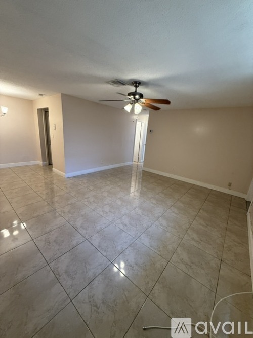 A spacious room with a ceiling fan and tile flooring.
