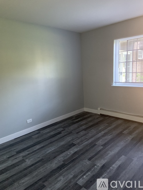 A room with a window and wooden flooring.