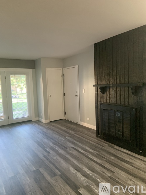 A room with a fireplace and wood flooring.