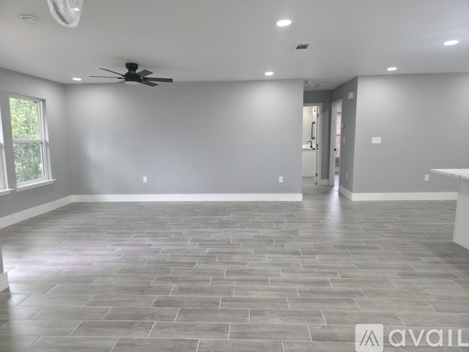 A spacious room with a ceiling fan and a tiled floor.