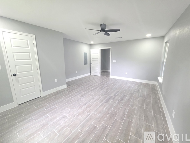 A spacious room with a ceiling fan and tiled flooring.