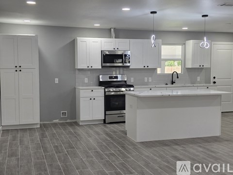 A modern kitchen with white cabinets and a central island.