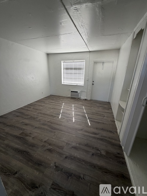 A room with wooden flooring and white walls.