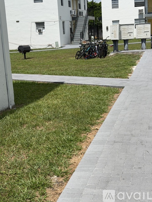 A white building with a grey walkway in front of it.