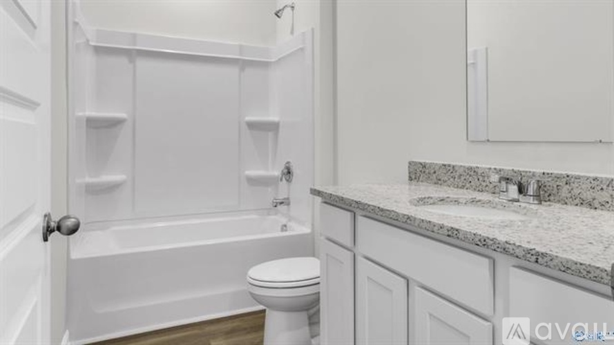 A white bathroom with a toilet, sink, and bathtub.