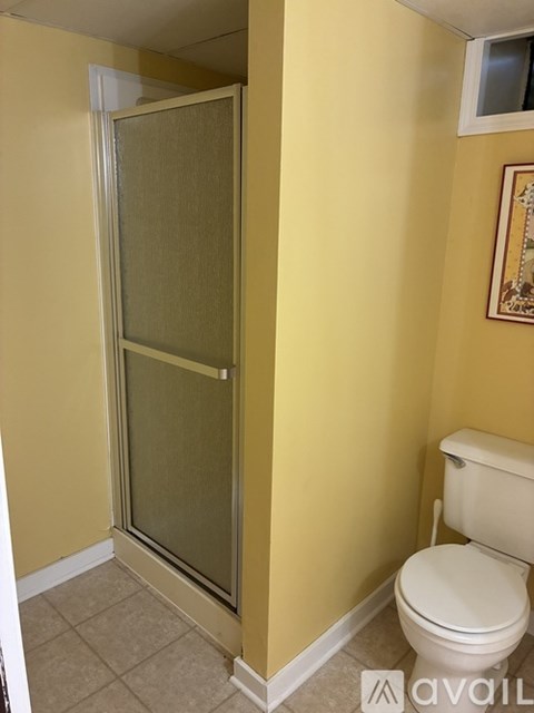 A bathroom with a toilet and a glass door.