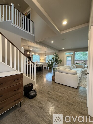 A living room with a white couch and a Christmas tree.