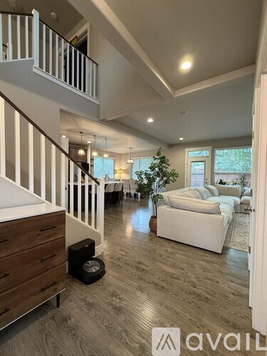 A living room with a white couch and a Christmas tree.