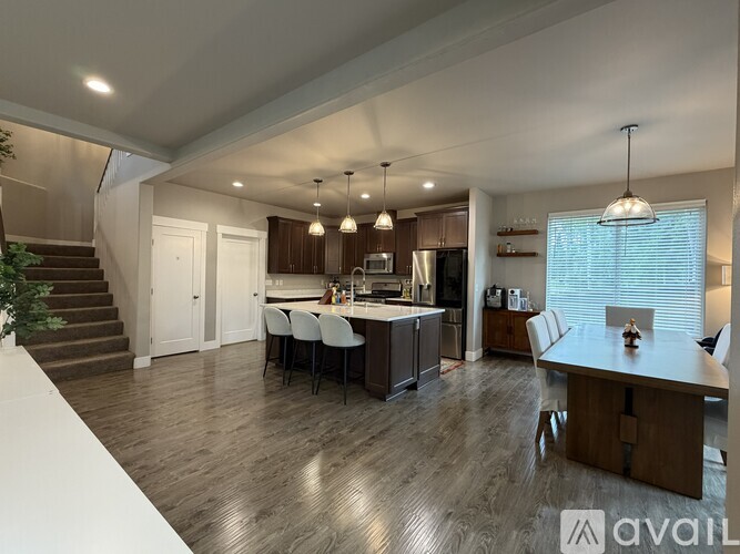 A spacious kitchen and dining area with wooden flooring and modern furnishings.