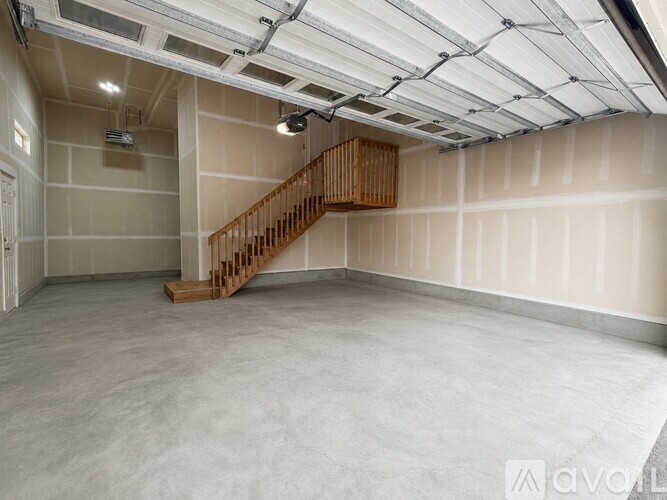 A spacious room with a wooden staircase and a projector.