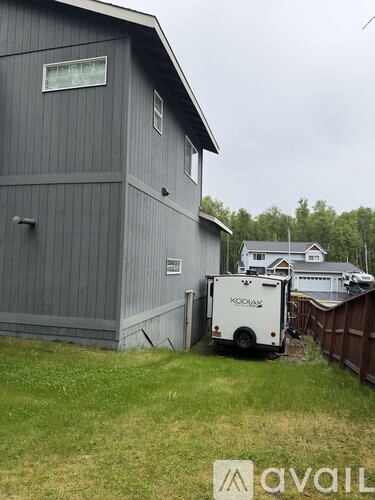 A white KODIAZ truck is parked in front of a grey building.