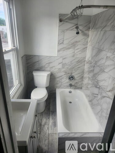 A bathroom with a toilet, sink and bathtub.