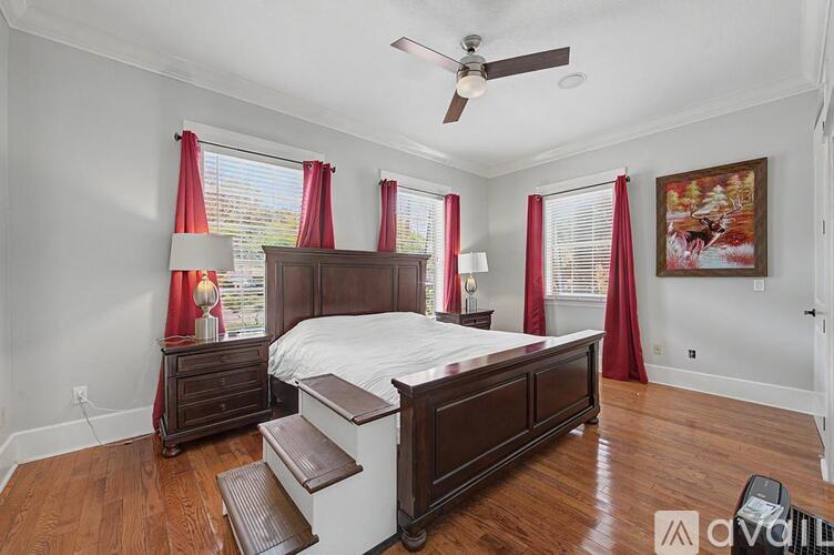 A bedroom with a large bed and a ceiling fan.
