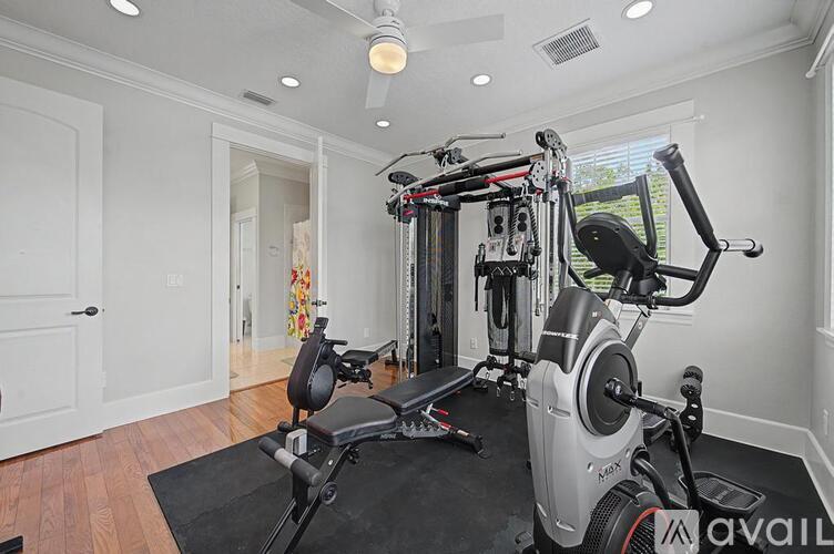 A home gym with a treadmill, elliptical trainer, and stationary bike.