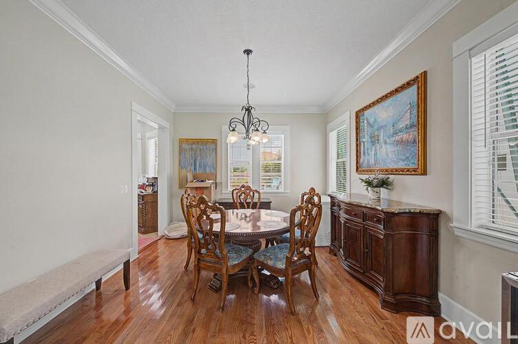 A dining room with a wooden table and chairs.