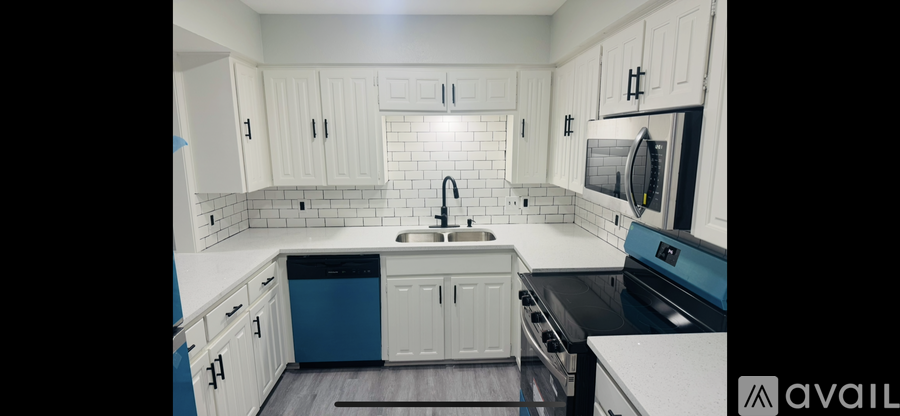 A kitchen with white cabinets and a blue dishwasher.