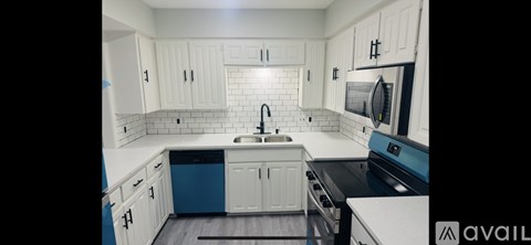 A kitchen with white cabinets and a blue dishwasher.