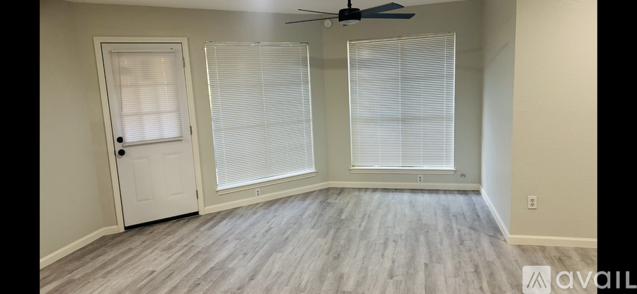 A room with a door, window, and a ceiling fan.
