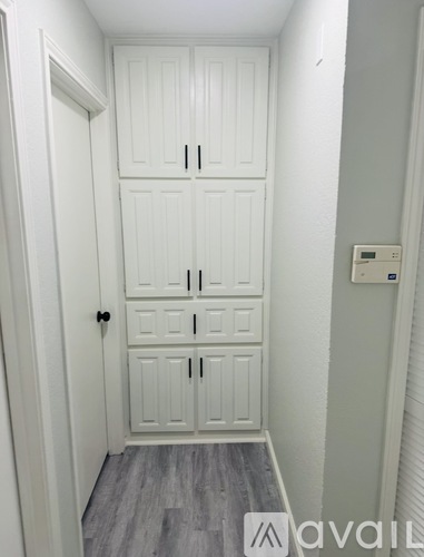 A white door with a black handle and a white cabinet with a black handle.