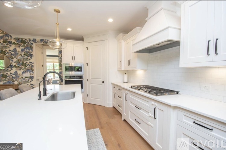 A kitchen with white cabinets and a white counter top.