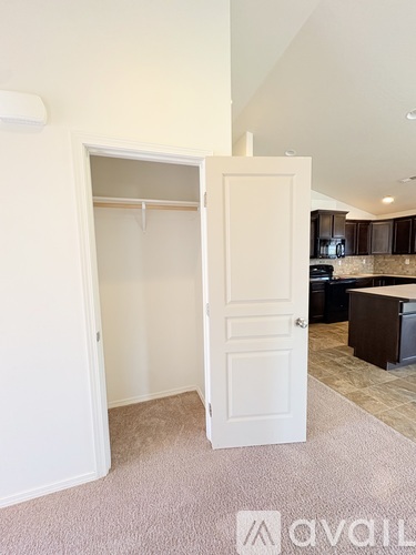 A spacious kitchen with dark cabinets and a tiled floor.