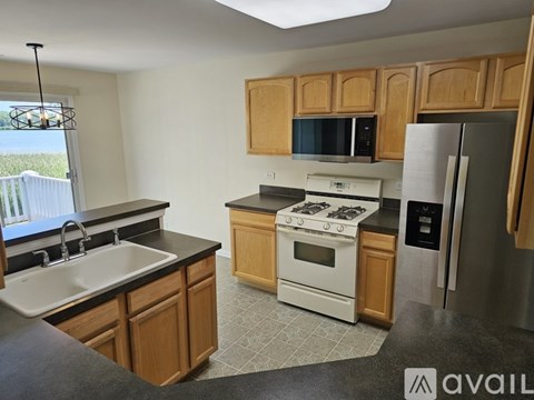 A kitchen with wooden cabinets and a white stove top oven.
