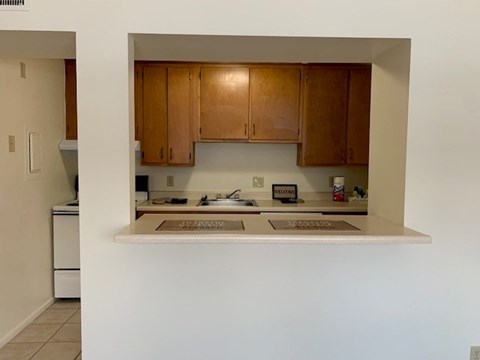 A kitchen with wooden cabinets and a white counter.