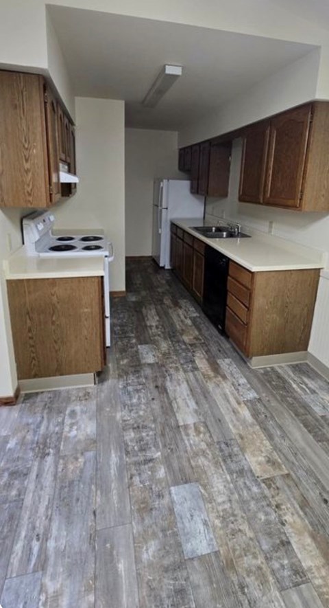 A kitchen with wooden cabinets and a tiled floor.