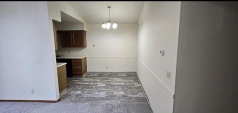 A room with a kitchen area and a long hallway.