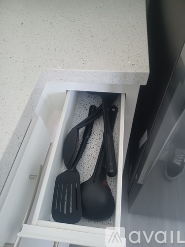 A drawer with utensils in it.
