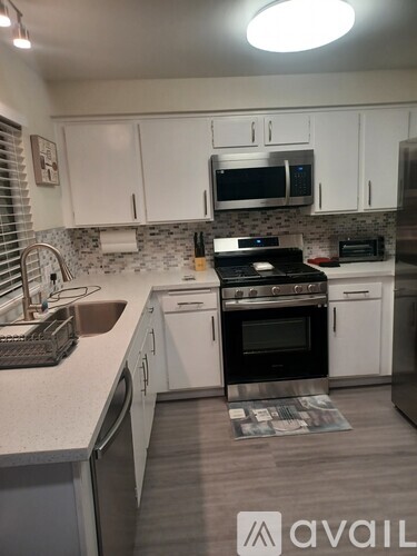 A kitchen with white cabinets and a black stove top oven.