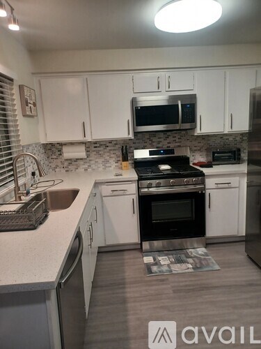 A kitchen with white cabinets and a black stove top oven.