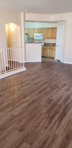 A room with wooden flooring and a white railing.