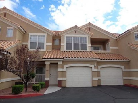 A large house with a red tile roof and a garage.