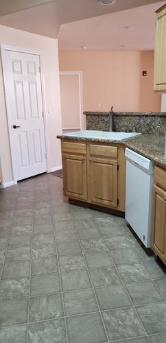 A kitchen with a white door and a white dishwasher.
