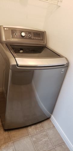 A silver dishwasher is sitting in a kitchen.