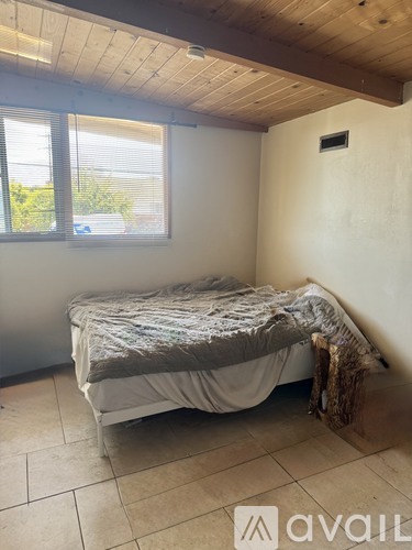 A bedroom with a bed and a window.